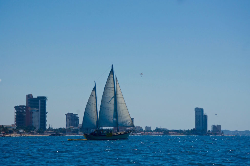 Big sailboat in front of the skyline of Mazatlan as seen from the ocean