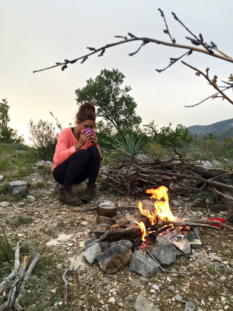 Sophie drinking tea in front of our campfire